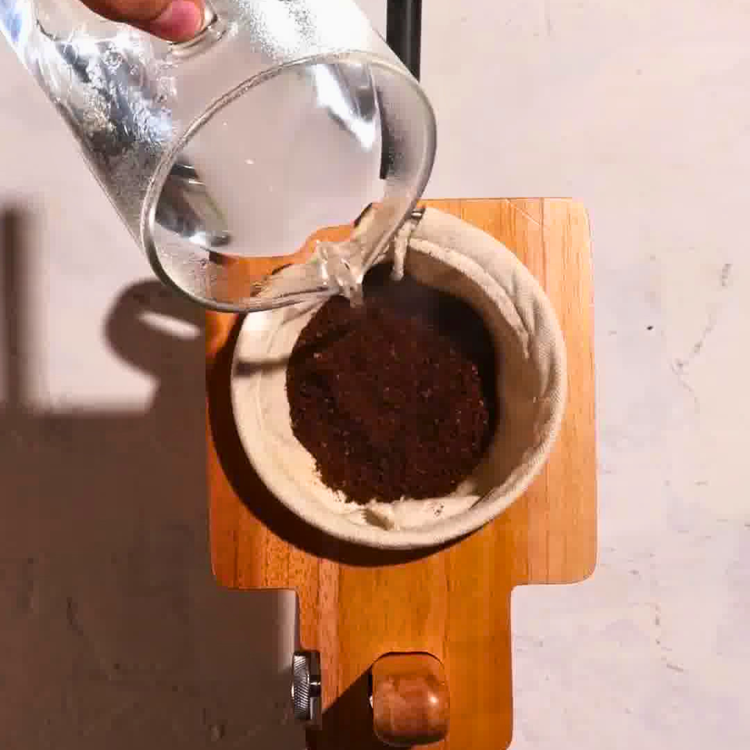 Water poured over ground coffee while brewing with the Plinc filter.